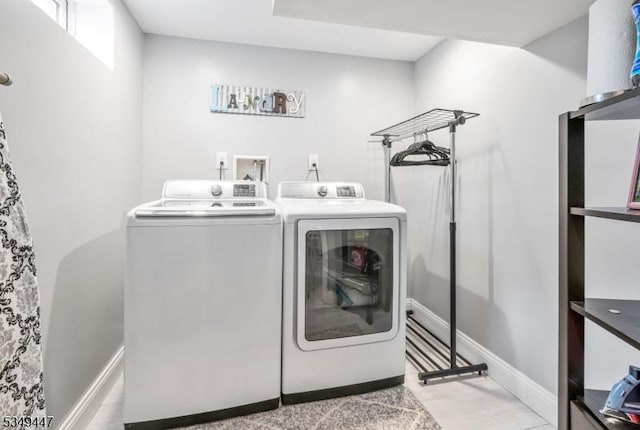 washroom with laundry area, baseboards, and washing machine and dryer