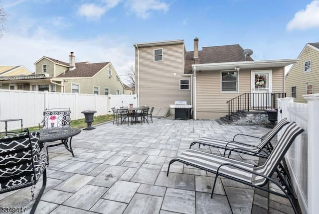 back of house featuring outdoor dining space, a patio area, and a fenced backyard