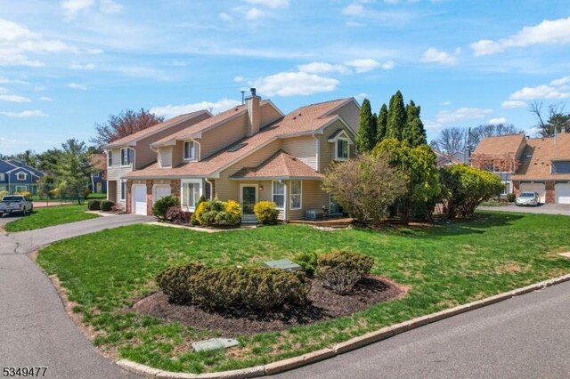 view of front of house with a front lawn, an attached garage, and aphalt driveway