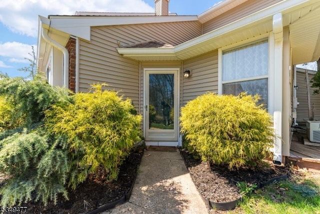 view of exterior entry with a chimney
