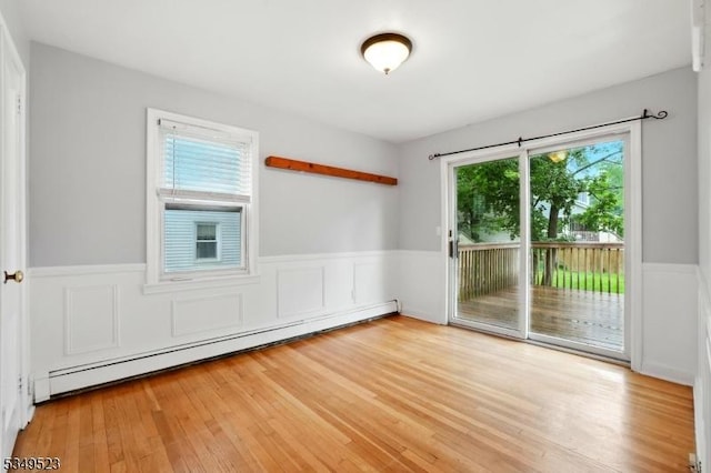 59 James St, Morristown Town, NJ 07960 - empty room featuring baseboard heating, wainscoting, wood finished floors, and a decorative wall