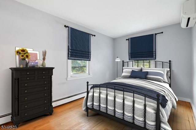 59 James St, Morristown Town, NJ 07960 - bedroom with a wall mounted air conditioner, a baseboard heating unit, and light wood finished floors