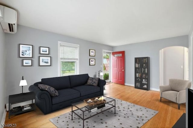59 James St, Morristown Town, NJ 07960 - living room with arched walkways, an AC wall unit, and light wood-style floors