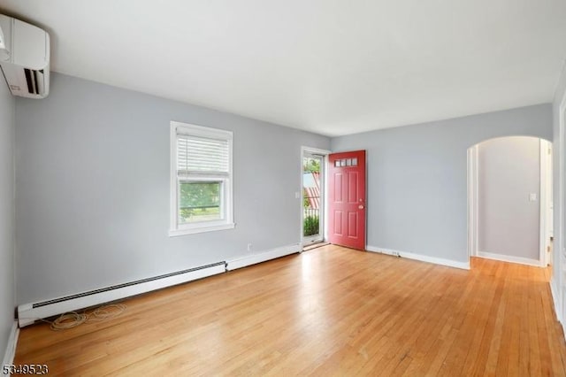 59 James St, Morristown Town, NJ 07960 - spare room featuring arched walkways, baseboard heating, light wood-style flooring, and a wall mounted air conditioner
