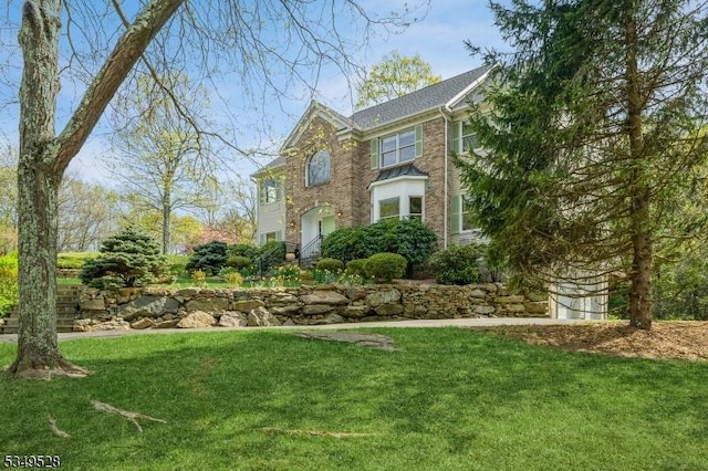 view of front of home with a front lawn and brick siding