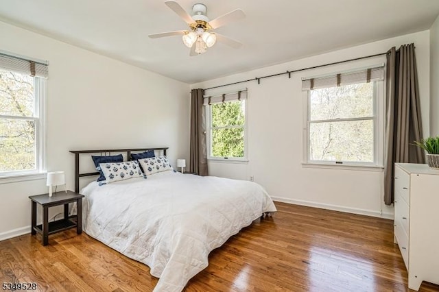 bedroom featuring wood finished floors, baseboards, and a ceiling fan