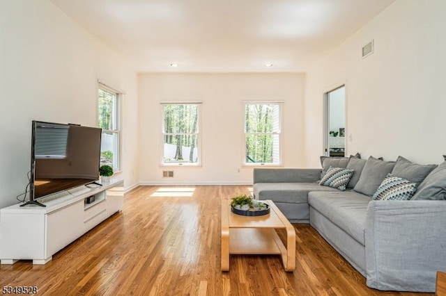 living area featuring light wood-type flooring, recessed lighting, and baseboards