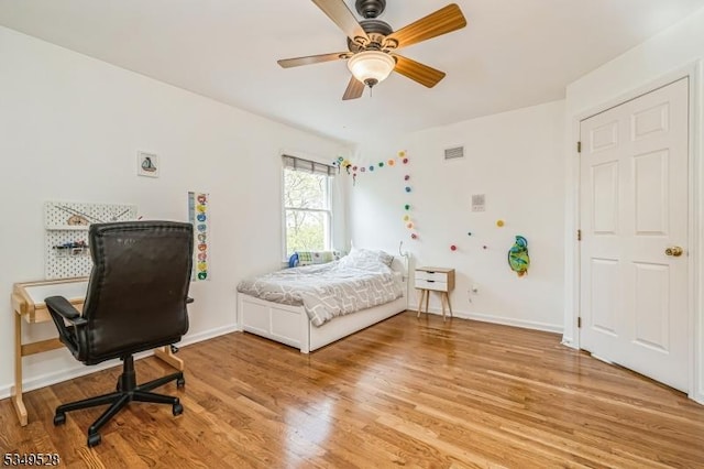 bedroom with light wood-style floors, baseboards, and a ceiling fan
