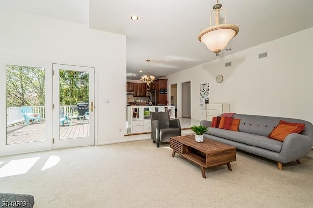 living room featuring light colored carpet, a chandelier, and recessed lighting
