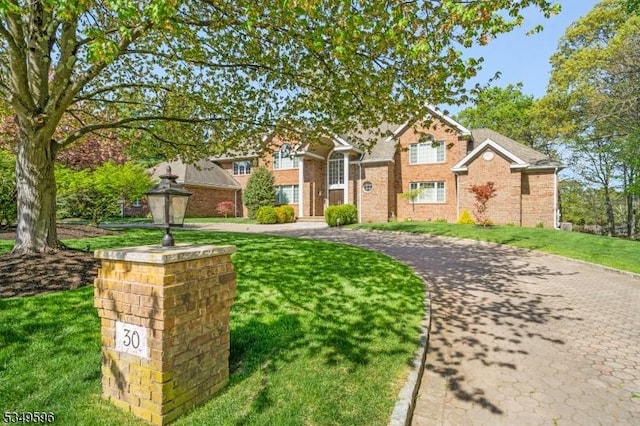 30 Mountain Ridge Dr, Livingston Twp, NJ 07039 - traditional home featuring a front yard, brick siding, and curved driveway