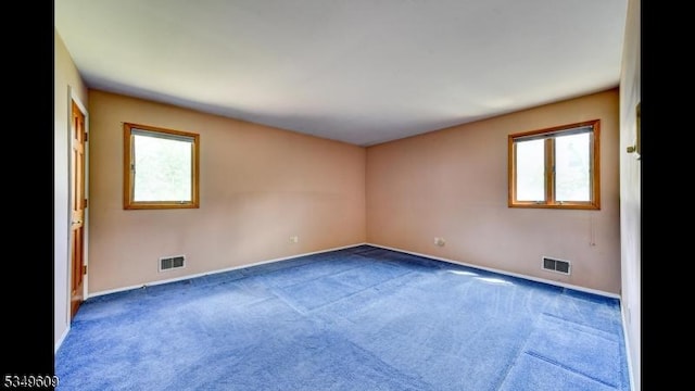 unfurnished room with carpet floors, baseboards, and visible vents