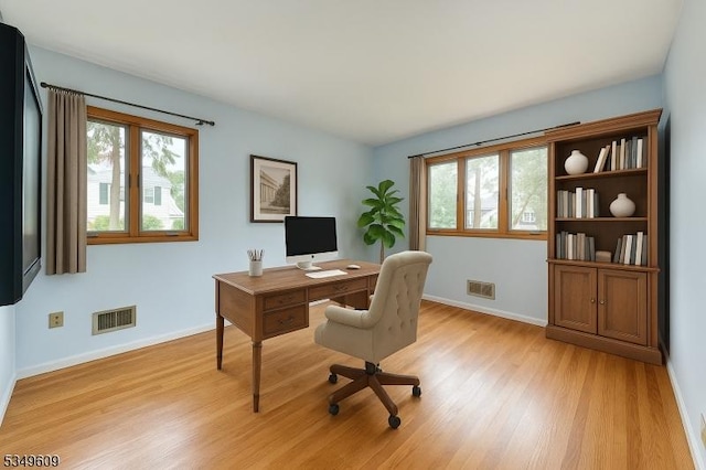 home office with visible vents, light wood-style floors, and baseboards