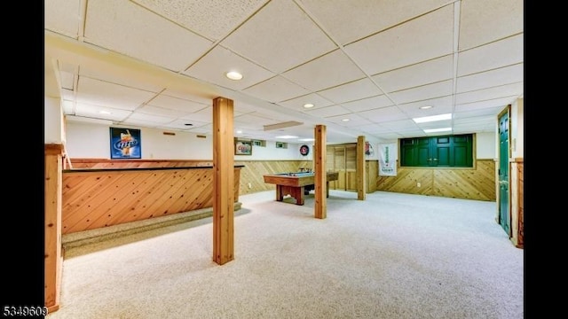 finished below grade area with wood walls, billiards, carpet flooring, and a paneled ceiling