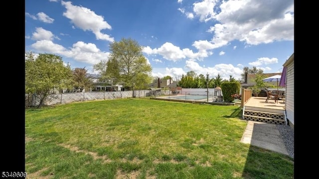 view of yard with fence, a fenced in pool, and a wooden deck
