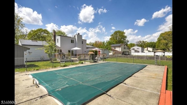 view of basketball court featuring a fenced in pool, fence, a yard, and a residential view