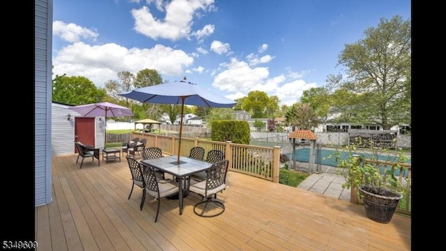 wooden deck with outdoor dining area and a fenced backyard