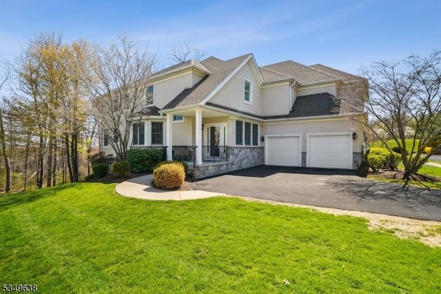 traditional-style home featuring a front lawn, stone siding, stucco siding, an attached garage, and driveway