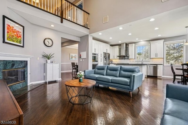 living area with recessed lighting, baseboards, and dark wood-style floors