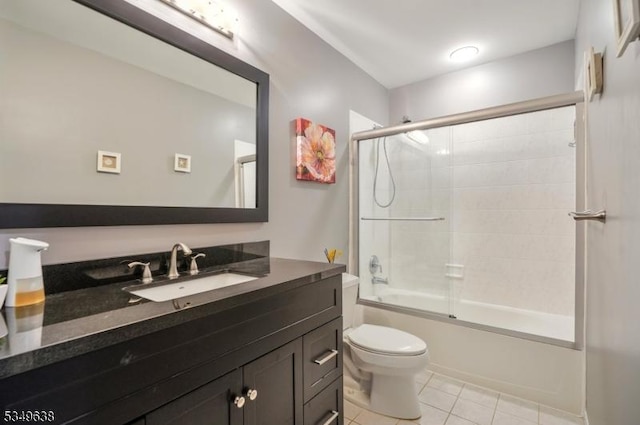 full bathroom featuring vanity, combined bath / shower with glass door, tile patterned floors, and toilet