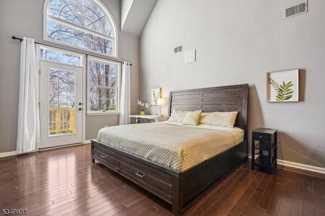 bedroom with high vaulted ceiling, visible vents, baseboards, and hardwood / wood-style floors