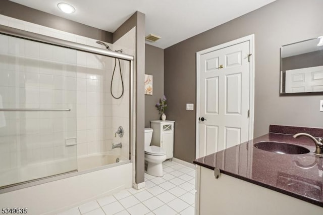 bathroom featuring vanity, toilet, tile patterned floors, baseboards, and combined bath / shower with glass door