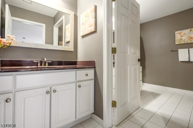 bathroom featuring tile patterned floors, baseboards, and vanity