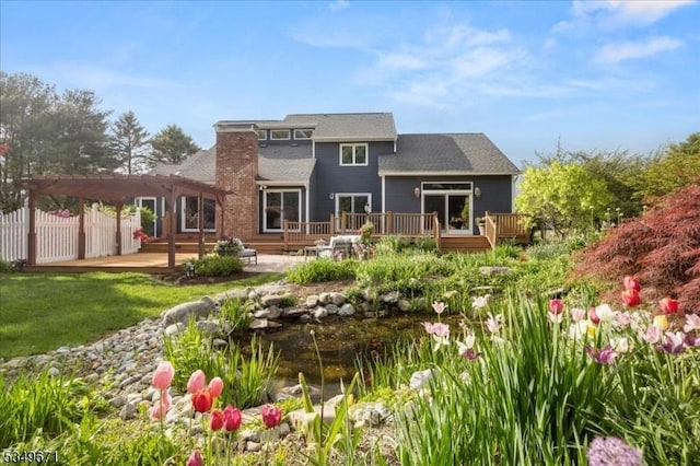 back of property featuring a pergola, a wooden deck, fence, and a patio area