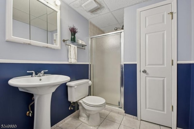 full bathroom with tile patterned flooring, baseboards, a stall shower, and toilet