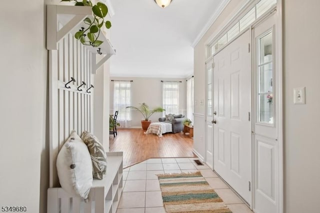 entrance foyer featuring crown molding, baseboards, and light tile patterned floors