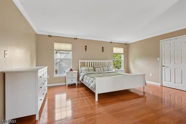 bedroom featuring crown molding, baseboards, and light wood-type flooring