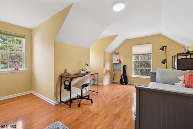 interior space with light wood-style floors, baseboards, lofted ceiling, and multiple windows