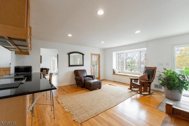 living area with recessed lighting, light wood finished floors, and baseboards