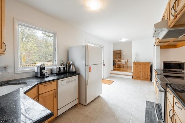 kitchen with light tile patterned floors, under cabinet range hood, a sink, and appliances with stainless steel finishes