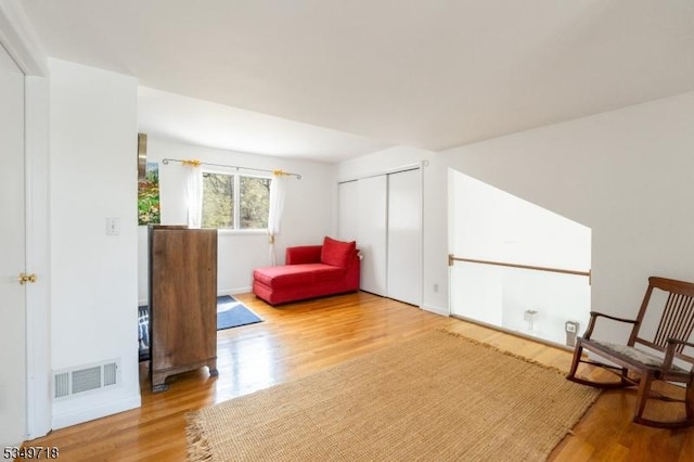 living area featuring wood finished floors and visible vents