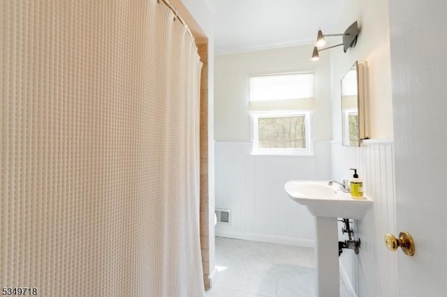 full bathroom featuring visible vents, tile patterned floors, and wainscoting