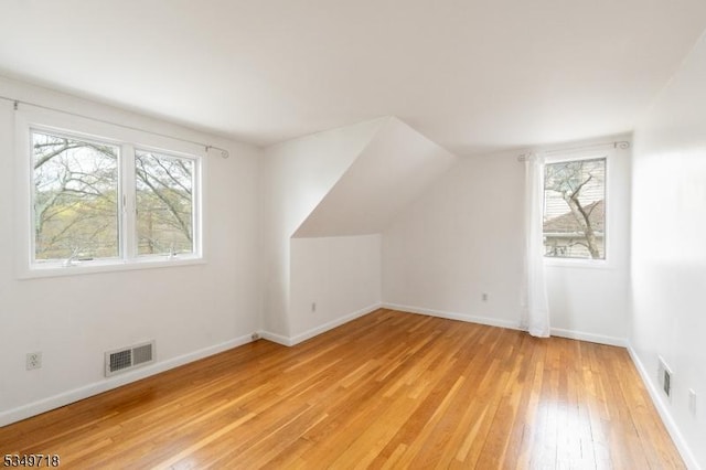 bonus room featuring light wood-style flooring, visible vents, and a wealth of natural light