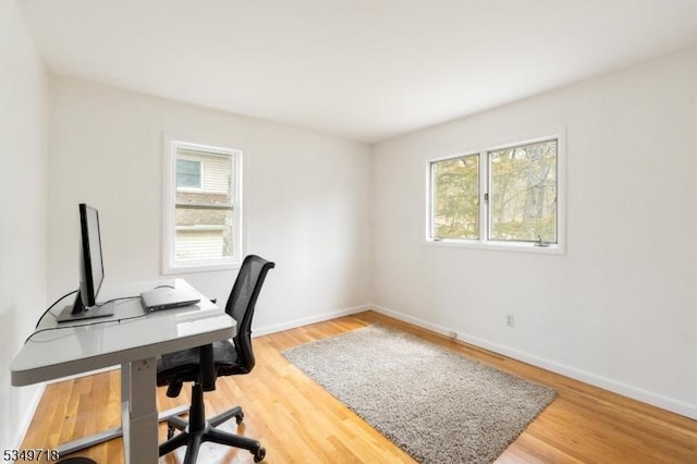 office with plenty of natural light, baseboards, and wood finished floors