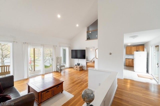 living area with recessed lighting, light wood-style floors, and high vaulted ceiling