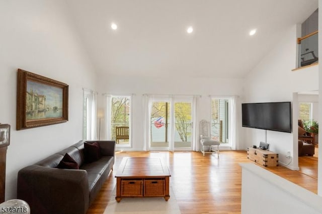 living area featuring recessed lighting, light wood-type flooring, and high vaulted ceiling