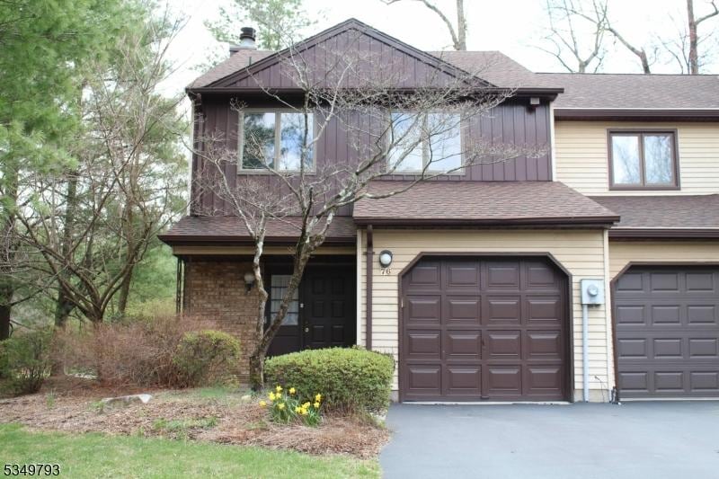 view of front of house with roof with shingles and aphalt driveway