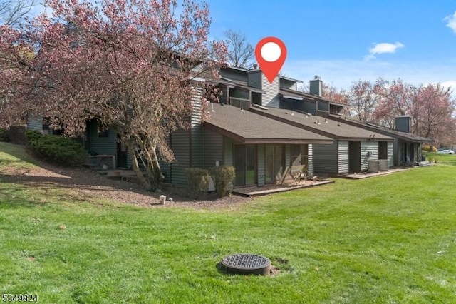back of property with a lawn and a chimney