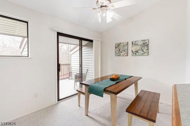 dining space with carpet floors, a ceiling fan, baseboards, and lofted ceiling
