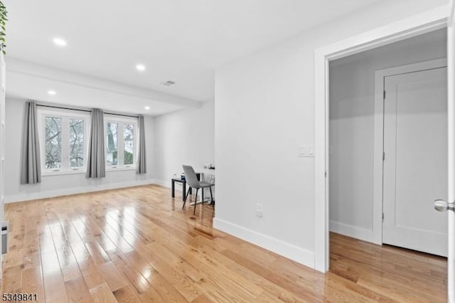 empty room featuring visible vents, light wood-style flooring, recessed lighting, and baseboards