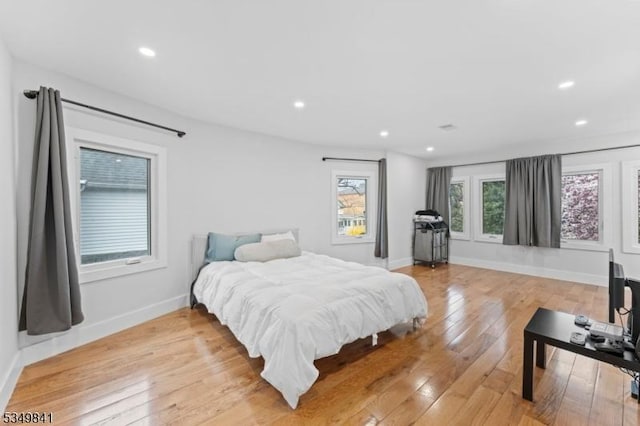 bedroom with recessed lighting, light wood finished floors, and baseboards