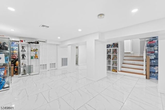 finished basement featuring marble finish floor, recessed lighting, visible vents, and stairs