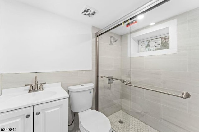full bath featuring visible vents, toilet, a shower stall, and vanity