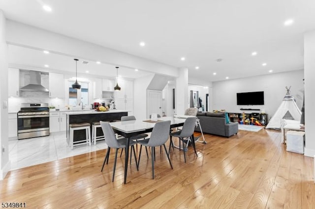 dining space featuring recessed lighting and light wood-style flooring