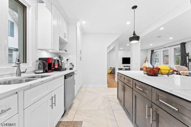 kitchen featuring dark brown cabinets, white cabinets, decorative light fixtures, stainless steel dishwasher, and a sink