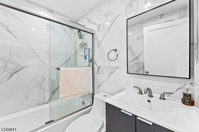 full bathroom with shower / bath combination with glass door, tasteful backsplash, vanity, toilet, and tile walls