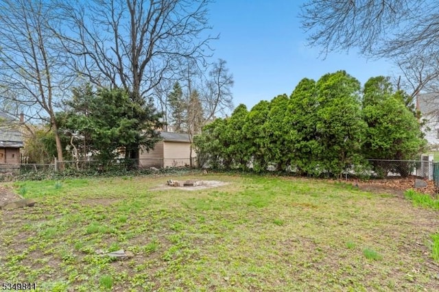view of yard with an outdoor fire pit and fence